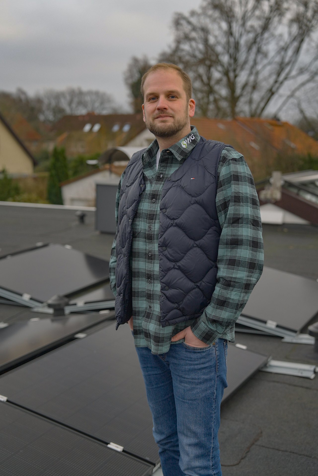 Johannes Uhl auf einem Dach mit fertig installierter PV-Anlage